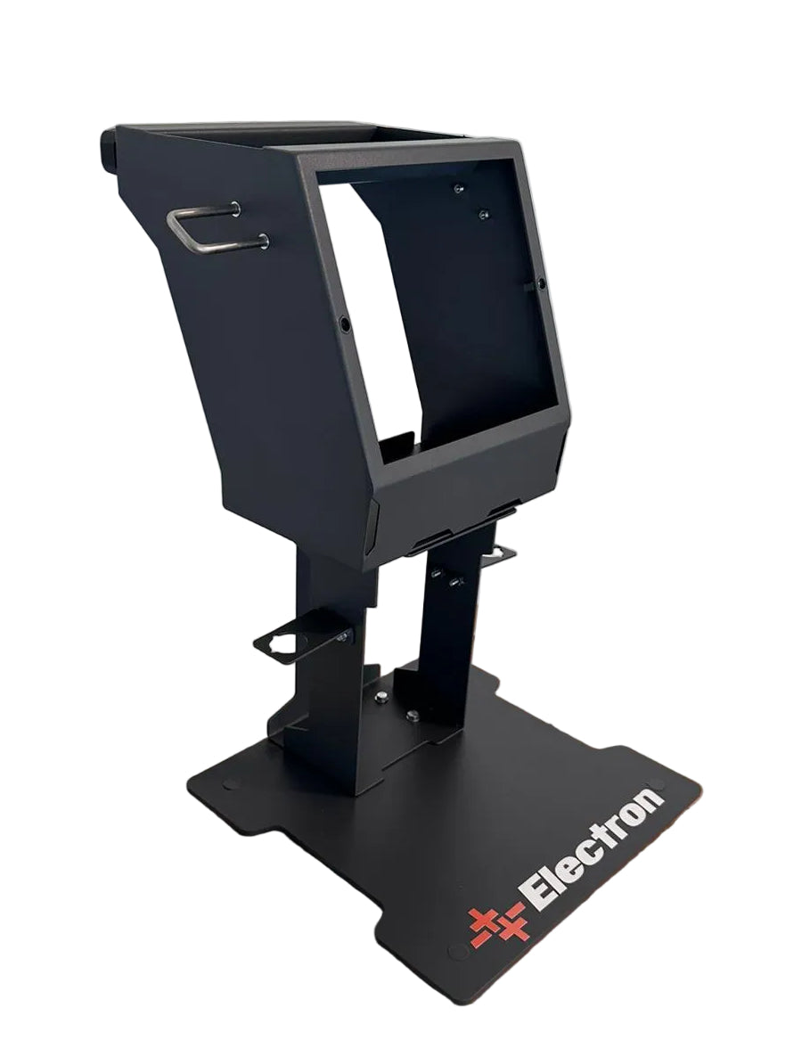 Black electronic device on a cardboard box with 'Electron' branding against a white wall.